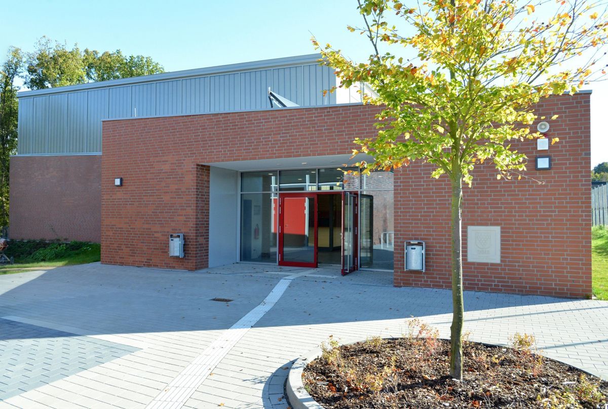 Ein Backsteingebäude mit einem Baum davor