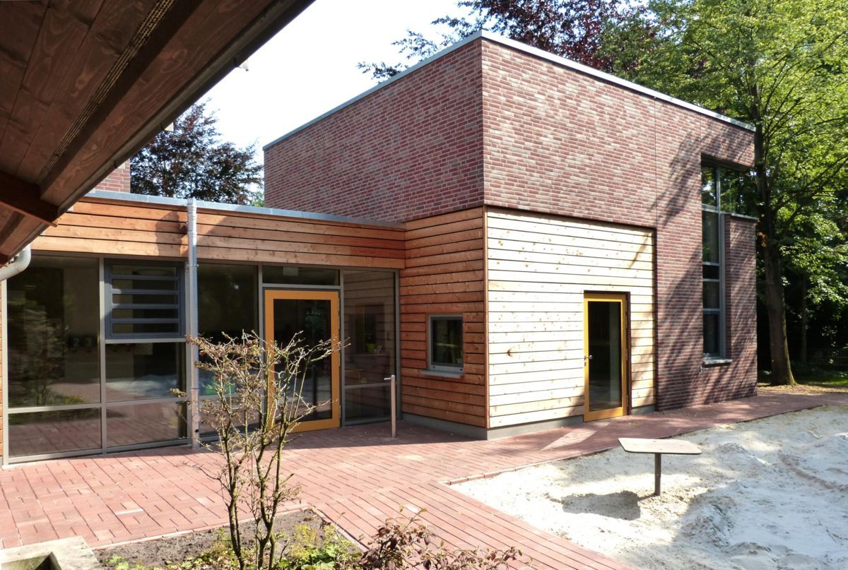 Ein Backsteingebäude mit einem Holzdach und einer gelben Tür