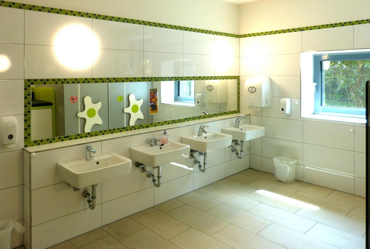 Ein Badezimmer mit vielen Waschbecken und Spiegeln