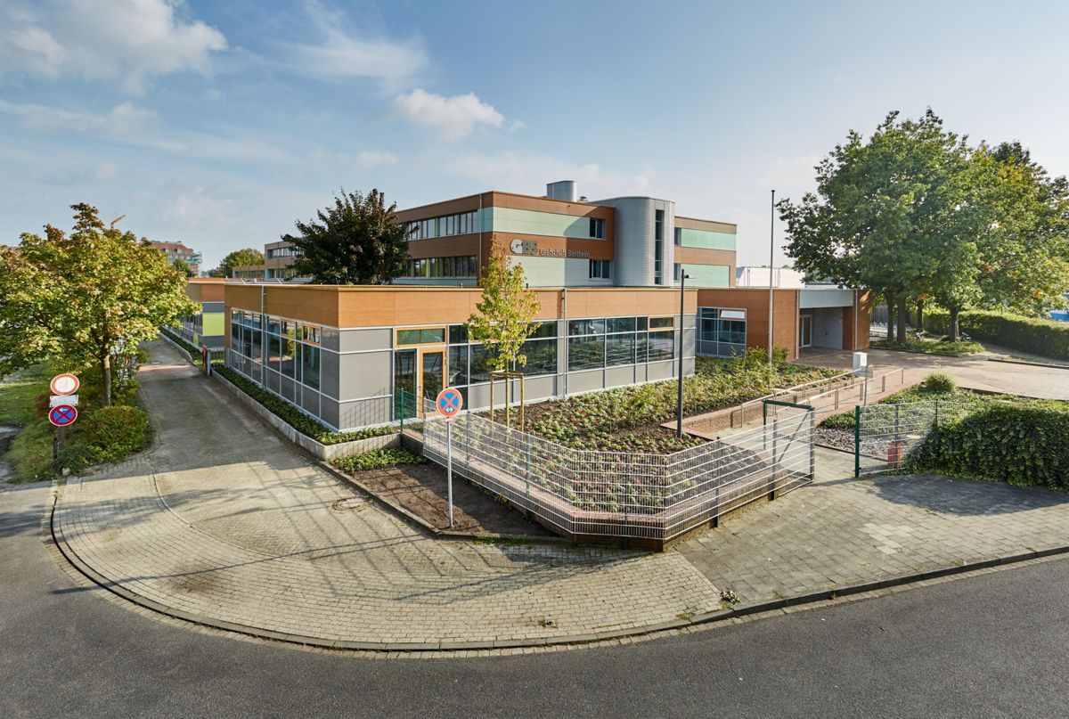 An einer Straßenecke steht ein großes Gebäude.