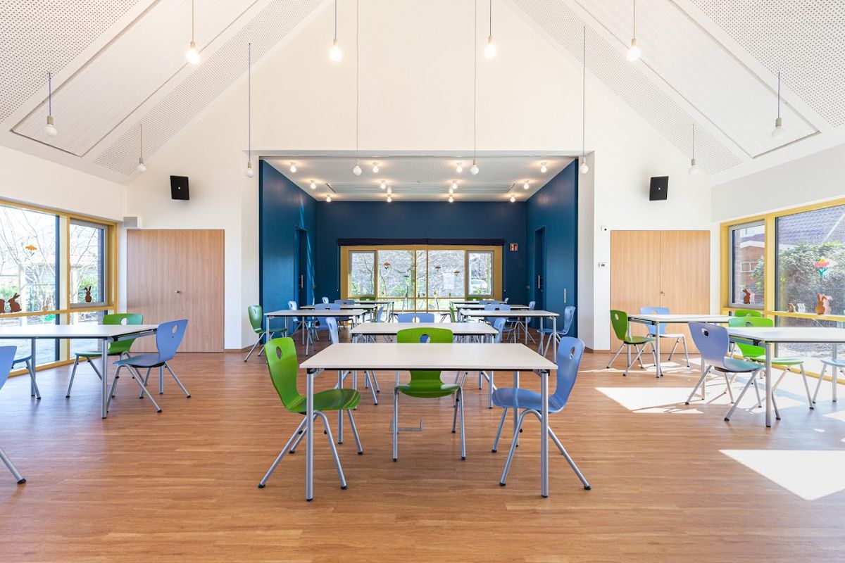 Ein großer Raum mit Tischen und Stühlen.