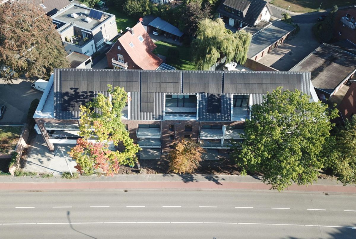 Eine Luftaufnahme eines Gebäudes mit Solarmodulen auf dem Dach.