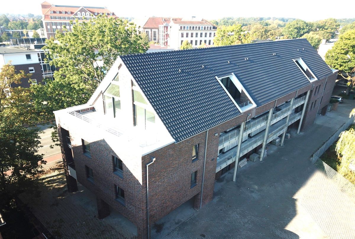 Eine Luftaufnahme eines Backsteingebäudes mit einem schwarzen Dach