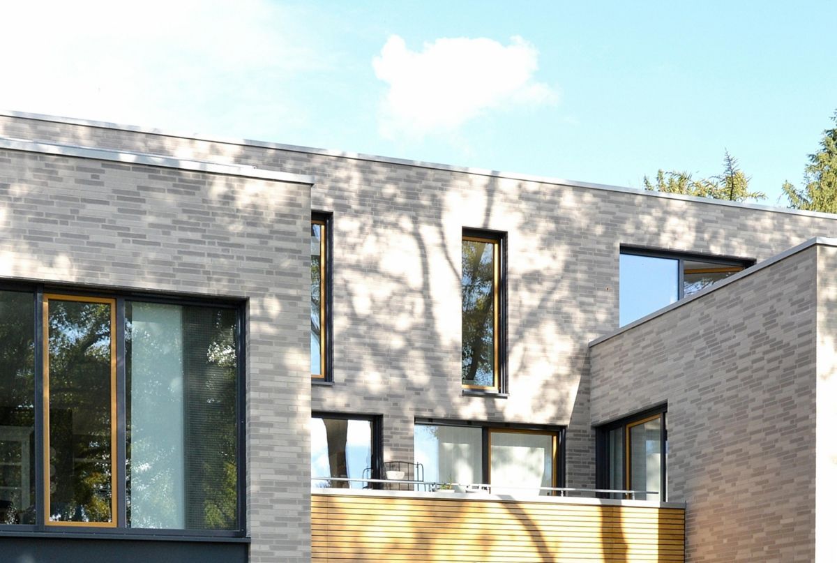 Ein großes Backsteingebäude mit vielen Fenstern und einem Balkon.