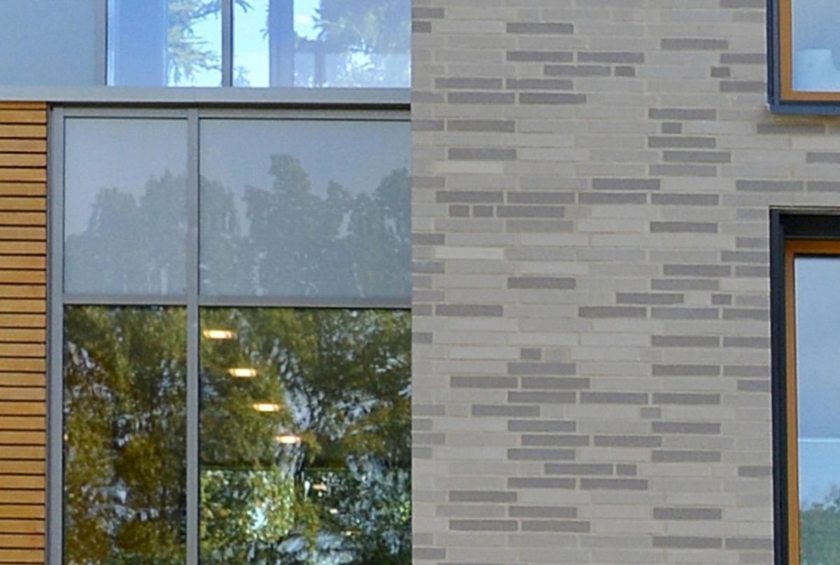 Ein Gebäude mit vielen Fenstern und einer Backsteinmauer.