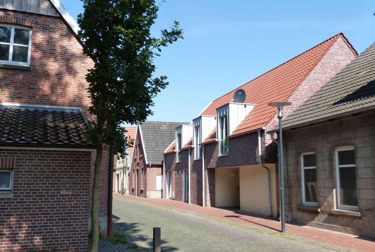 Eine Reihe von Backsteinhäusern in einer Kopfsteinpflasterstraße