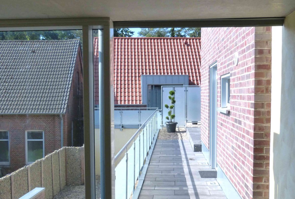 Ein Backsteingebäude mit einem roten Ziegeldach und einem Gehweg, der dorthin führt