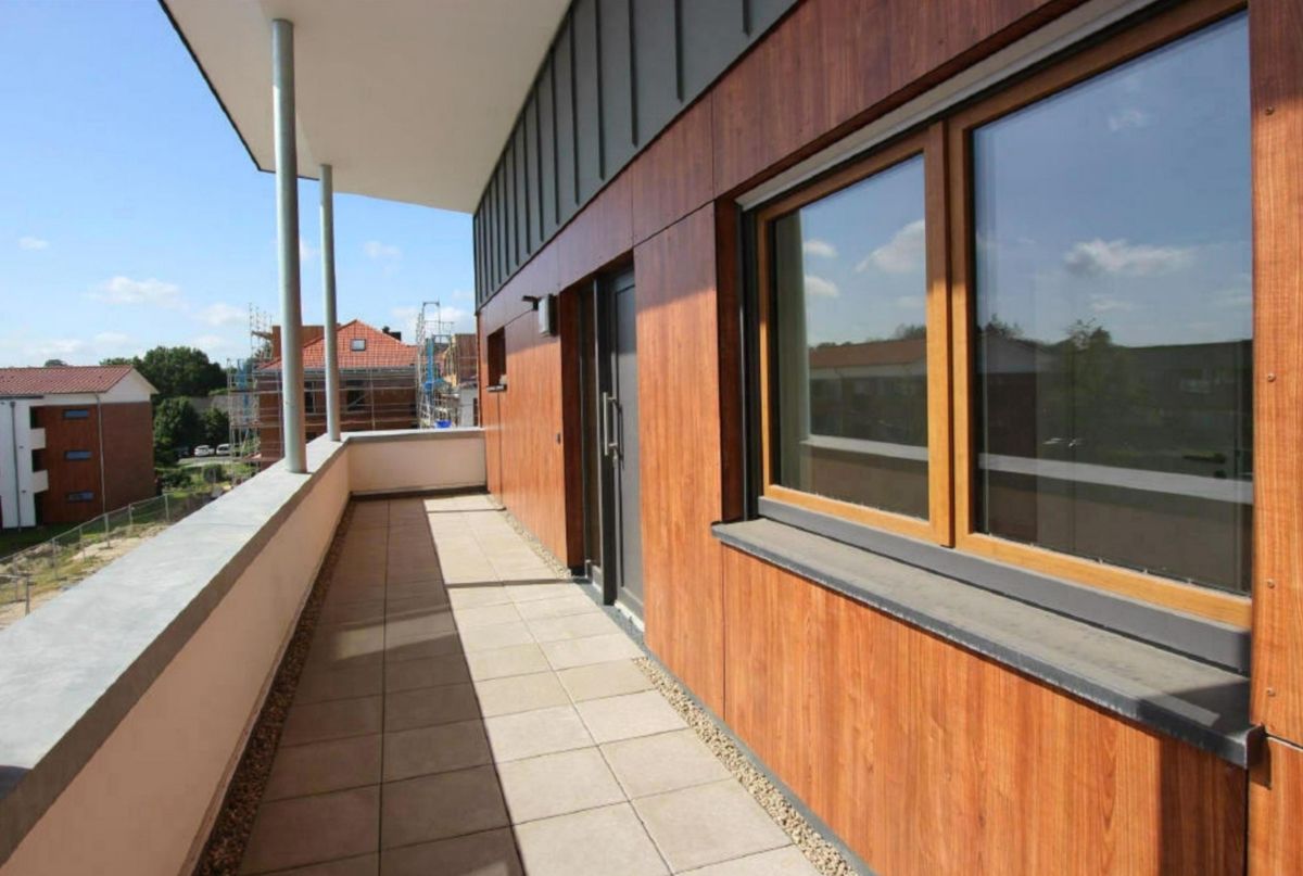 Ein Balkon an der Seite eines Gebäudes mit vielen Fenstern