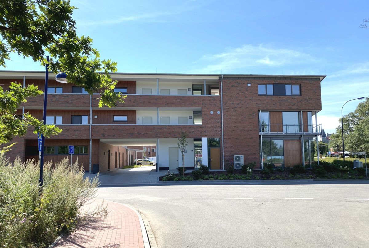 Ein großes Backsteingebäude mit einem Parkhaus darunter