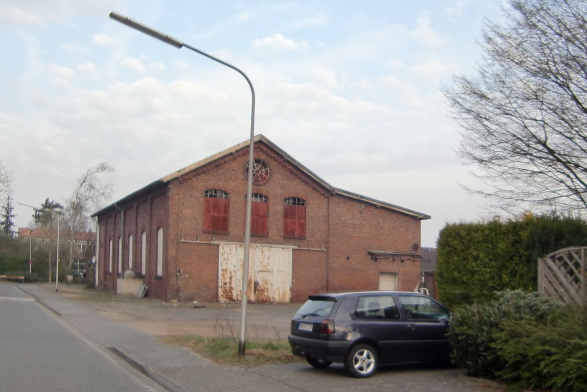 Ein schwarzes Auto steht vor einem Backsteingebäude