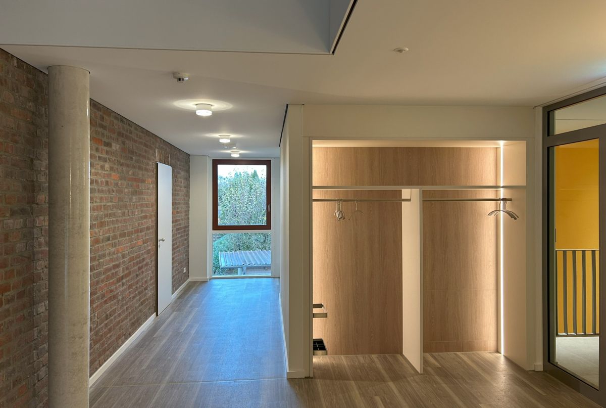 Ein leerer Flur mit einer Ziegelwand und einem Holzboden.