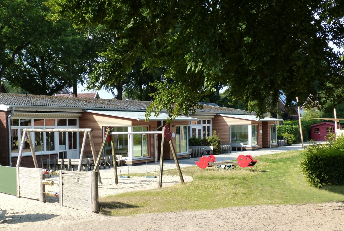 Ein Backsteingebäude mit einem Spielplatz davor