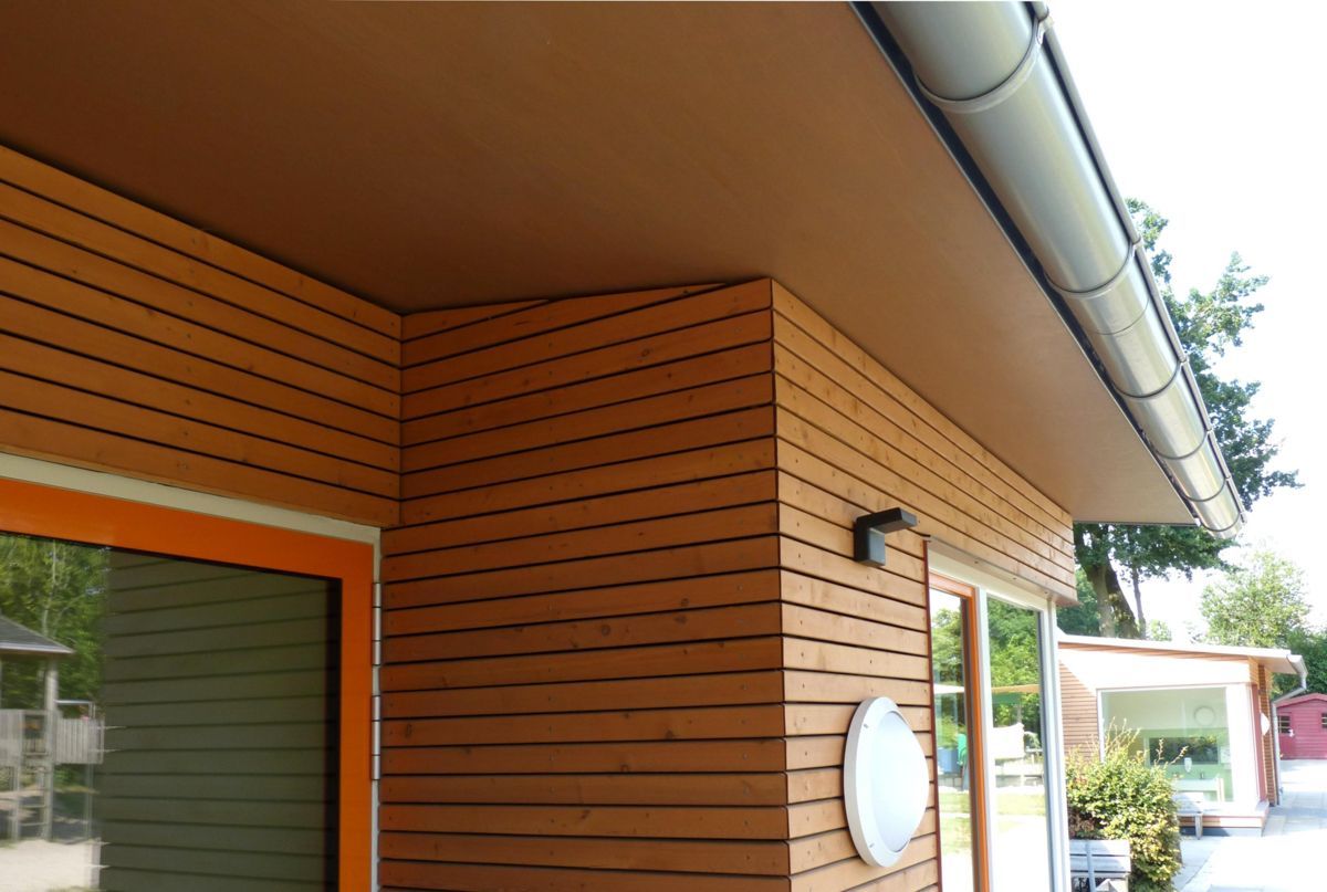 Ein Haus mit Holzverkleidung und einer weißen Dachrinne