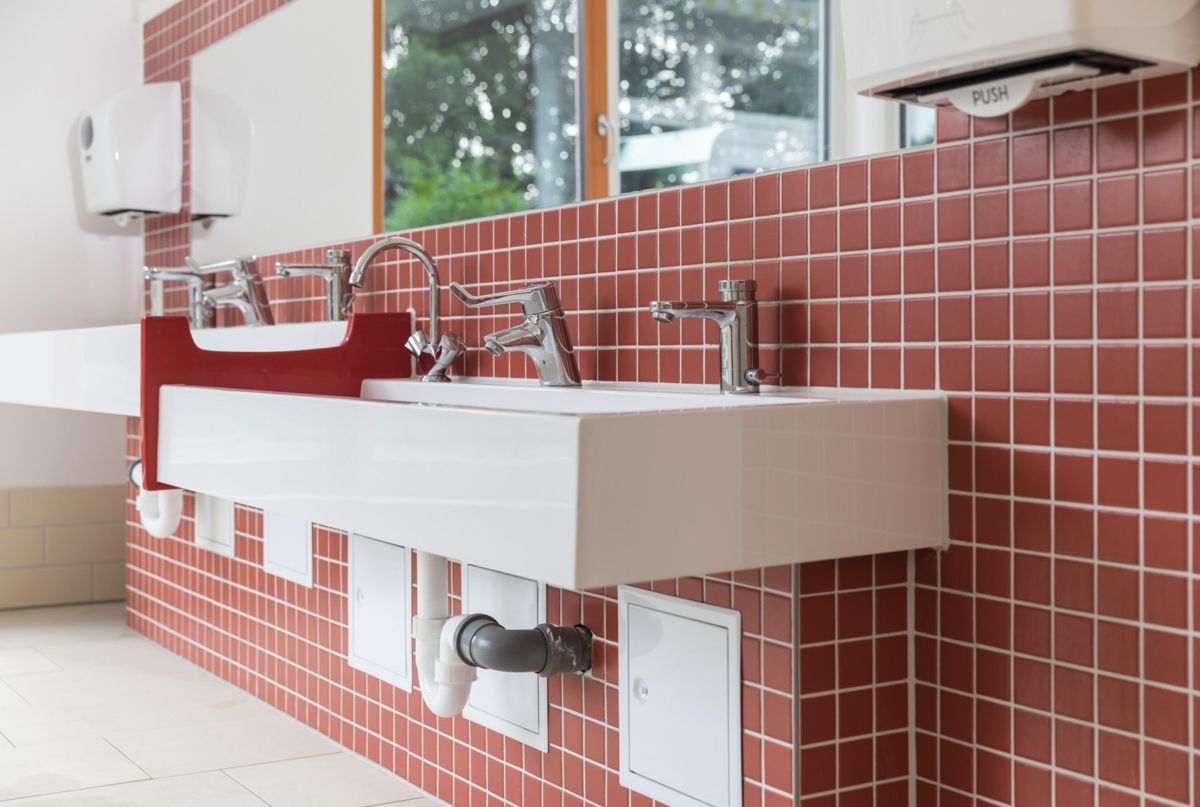 Ein Badezimmer mit roten Fliesen und zwei Waschbecken