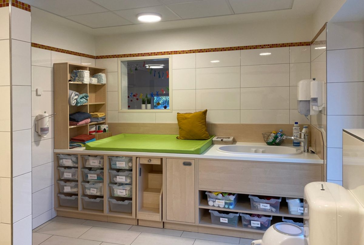 Ein Badezimmer mit Wickeltisch und Waschbecken