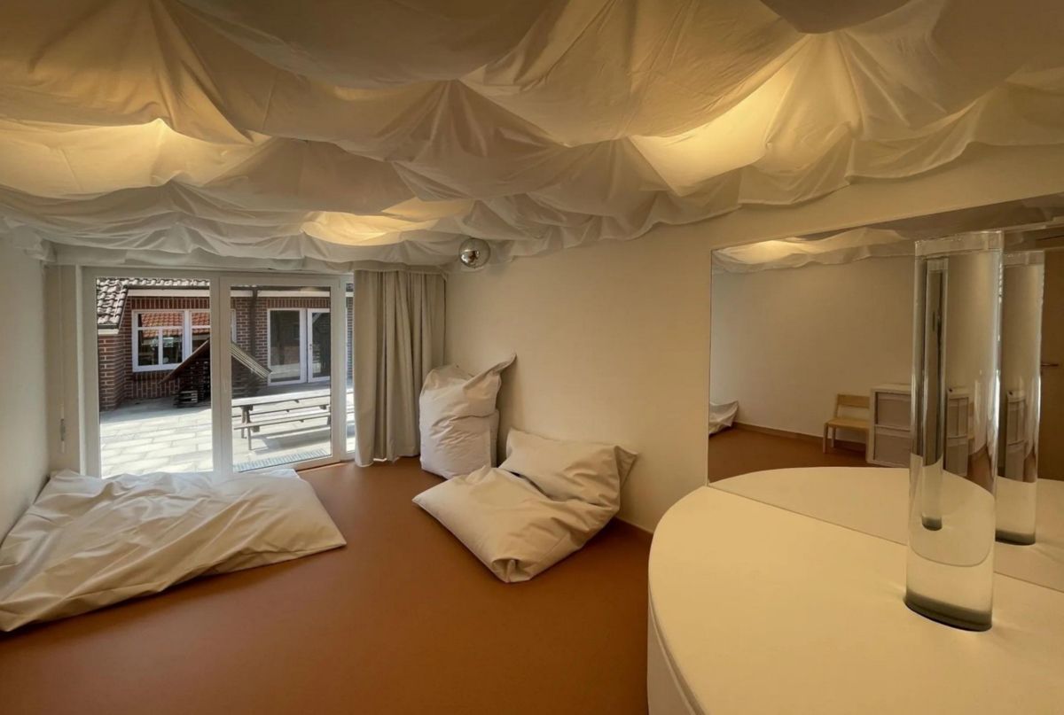 Ein Zimmer mit einem Bett, Kissen und einem Spiegel.