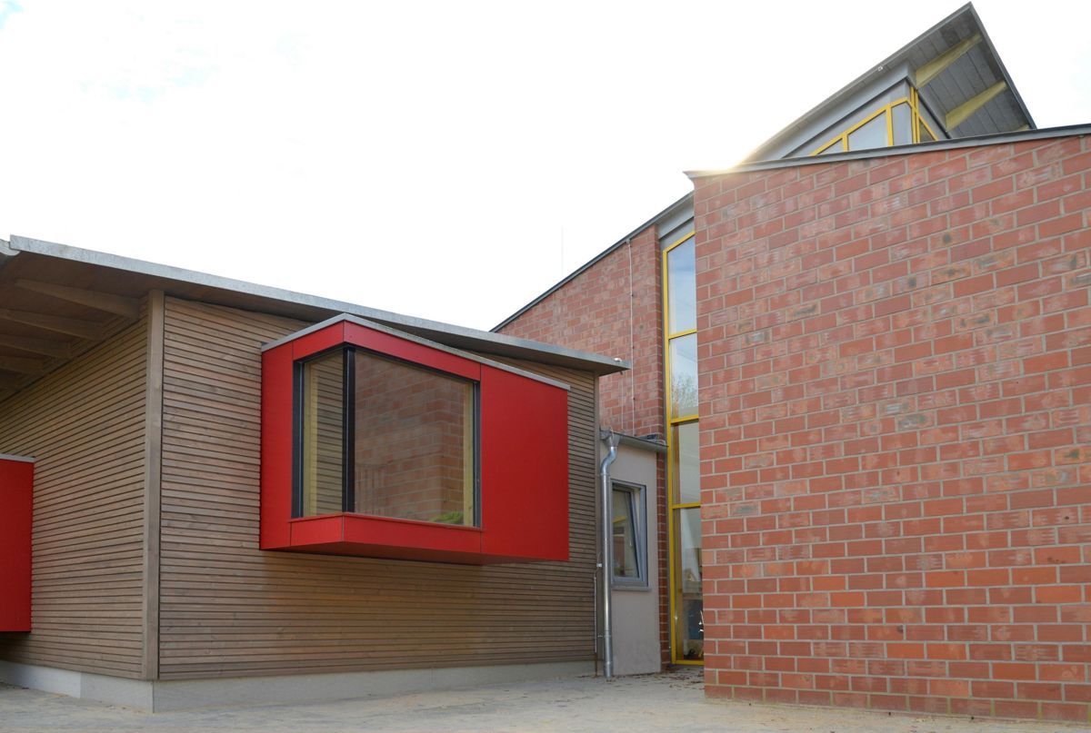 Ein Backsteingebäude mit einem roten Fenster an der Seite