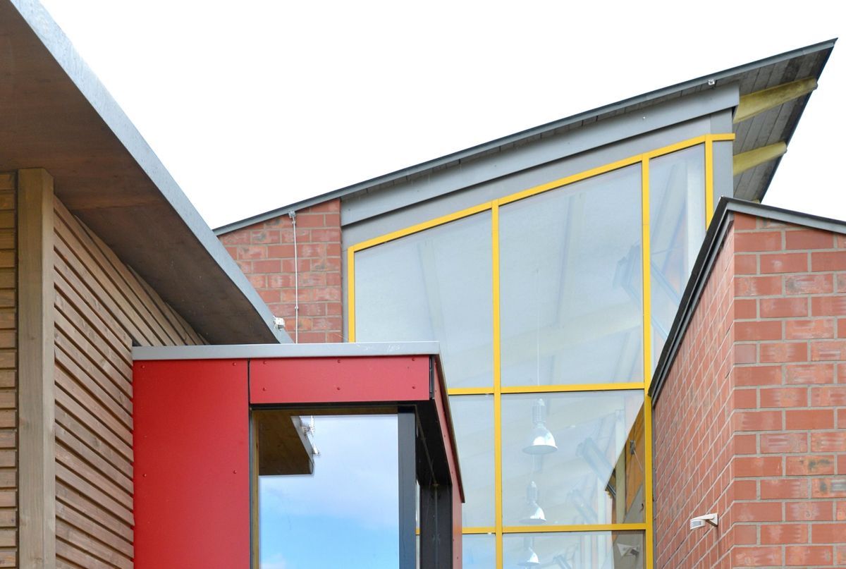 Ein rot-gelbes Gebäude mit einem großen Fenster