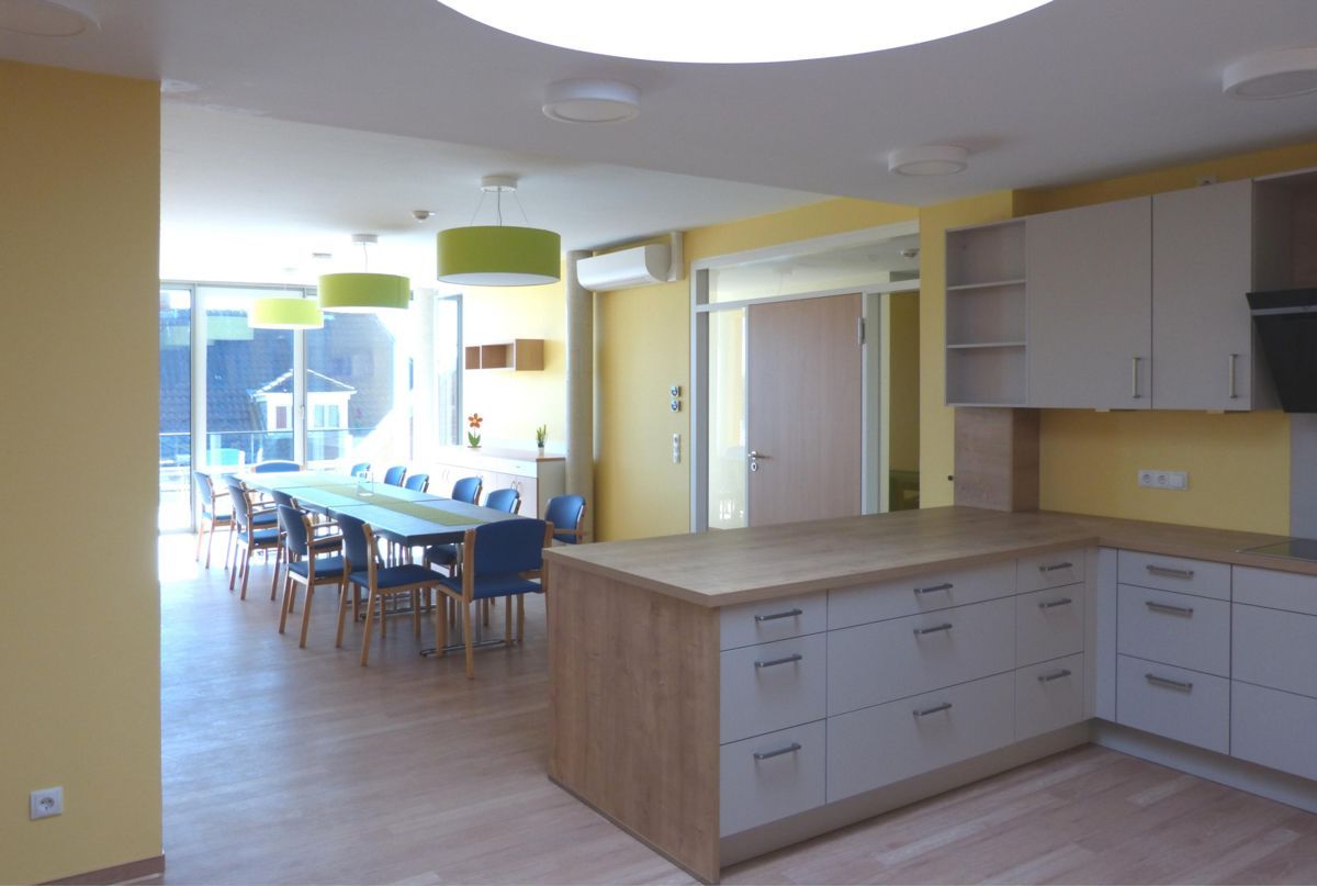 Eine Küche mit weißen Schränken und Holzarbeitsplatten