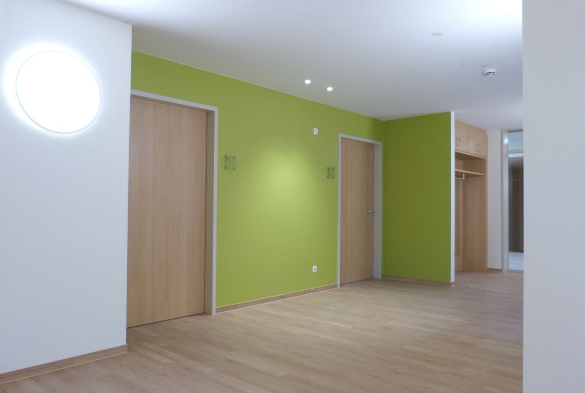 Ein leerer Flur mit grünen Wänden und Holzböden.