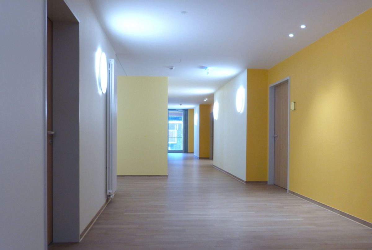 Ein leerer Flur mit gelben Wänden und Holzböden