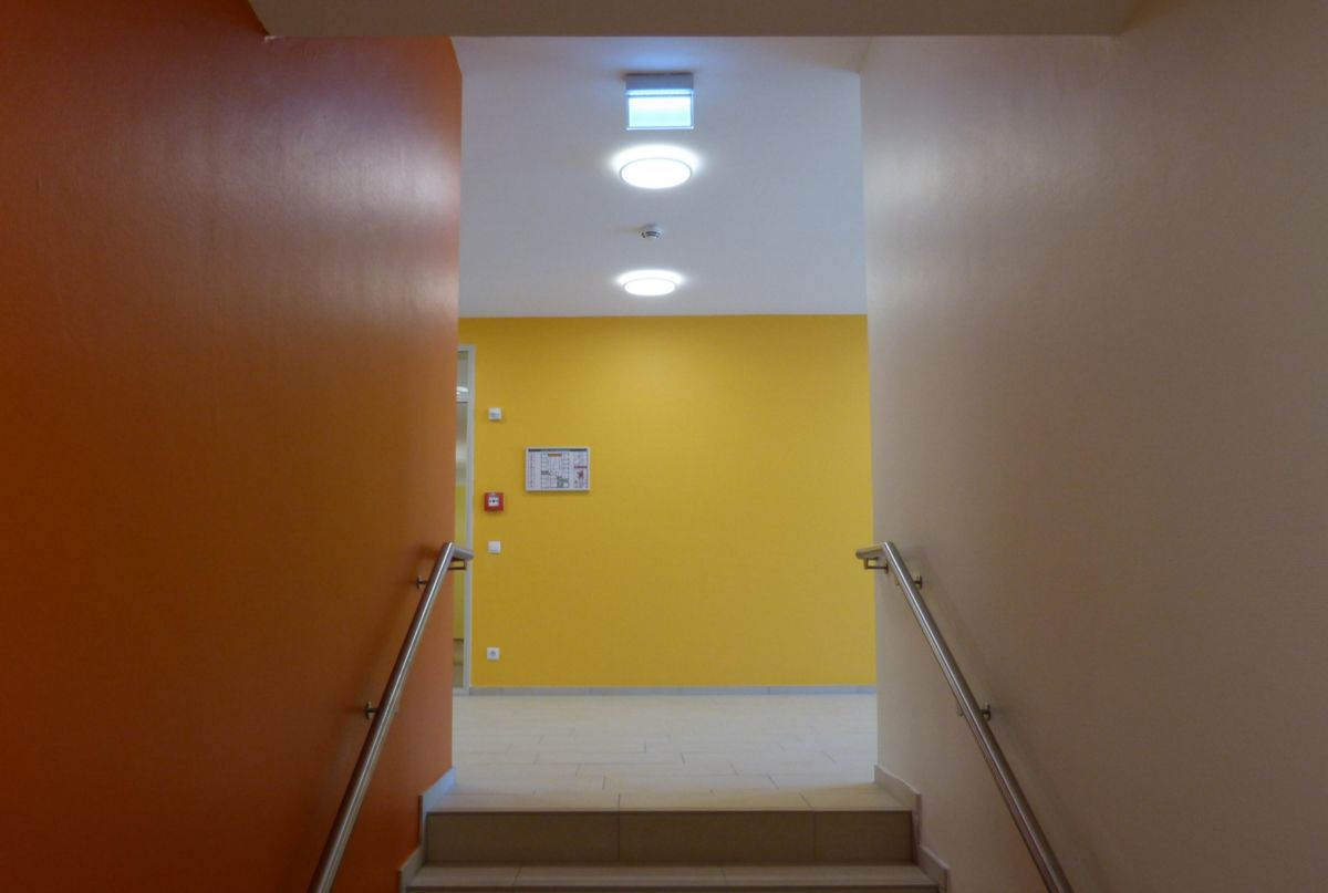 Ein Flur mit einer gelben Wand und einer Treppe, die dorthin führt