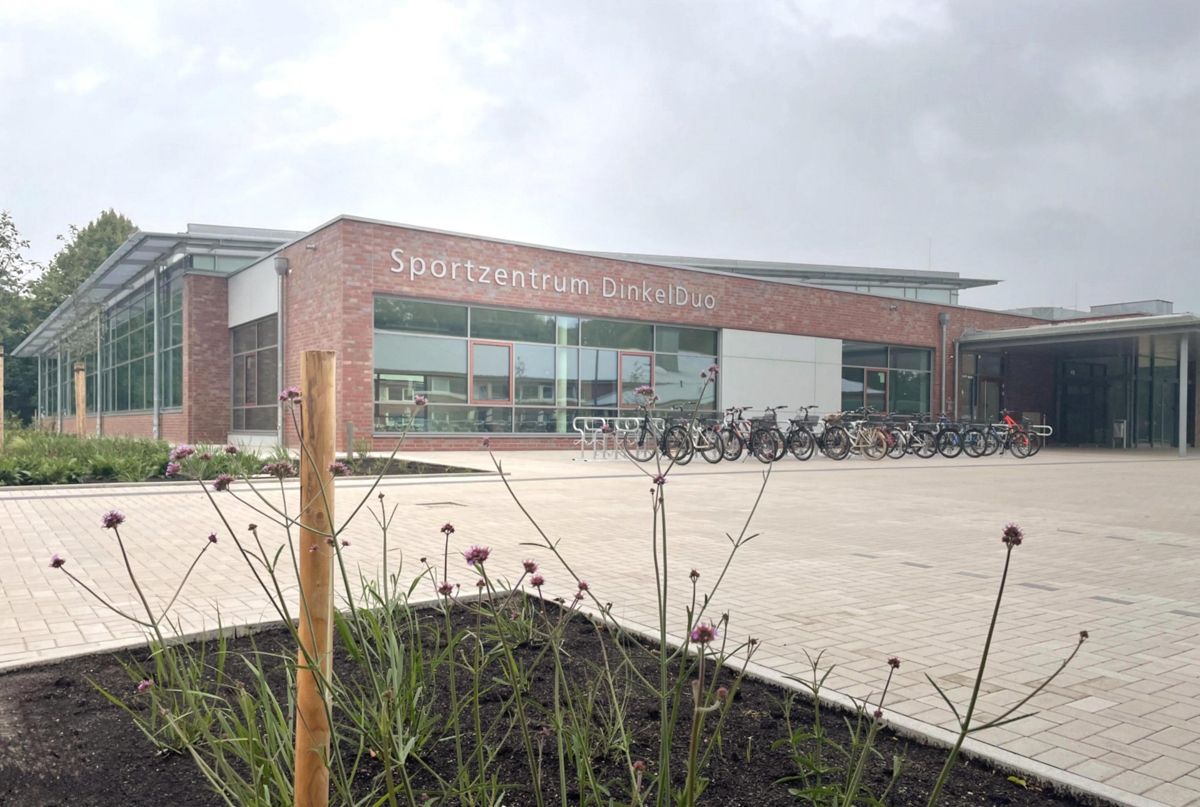 Ein großes Gebäude mit vielen Fenstern und davor geparkten Fahrrädern.