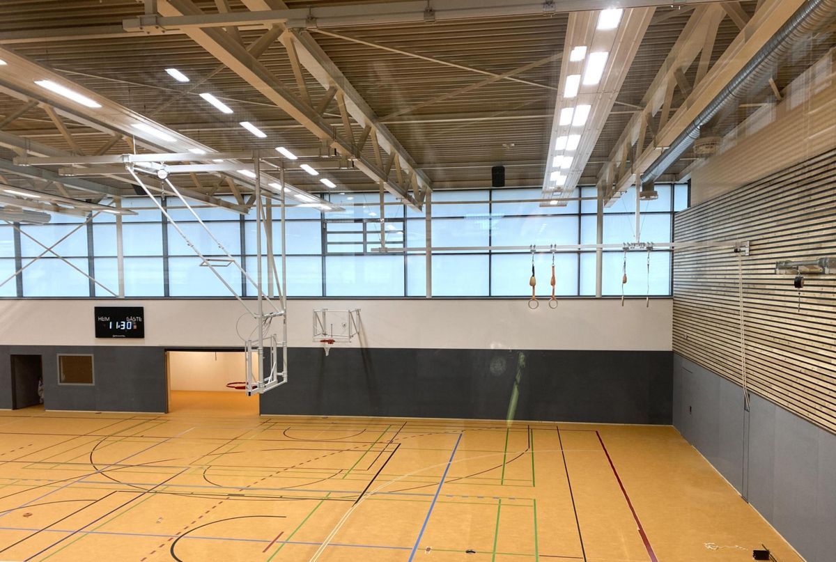 Ein großer Indoor-Basketballplatz mit vielen Fenstern.