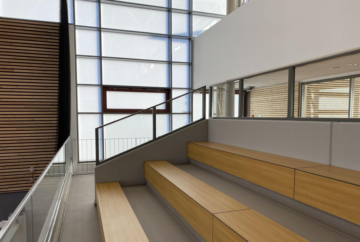 Eine Treppe mit Holzbänken und einem großen Fenster