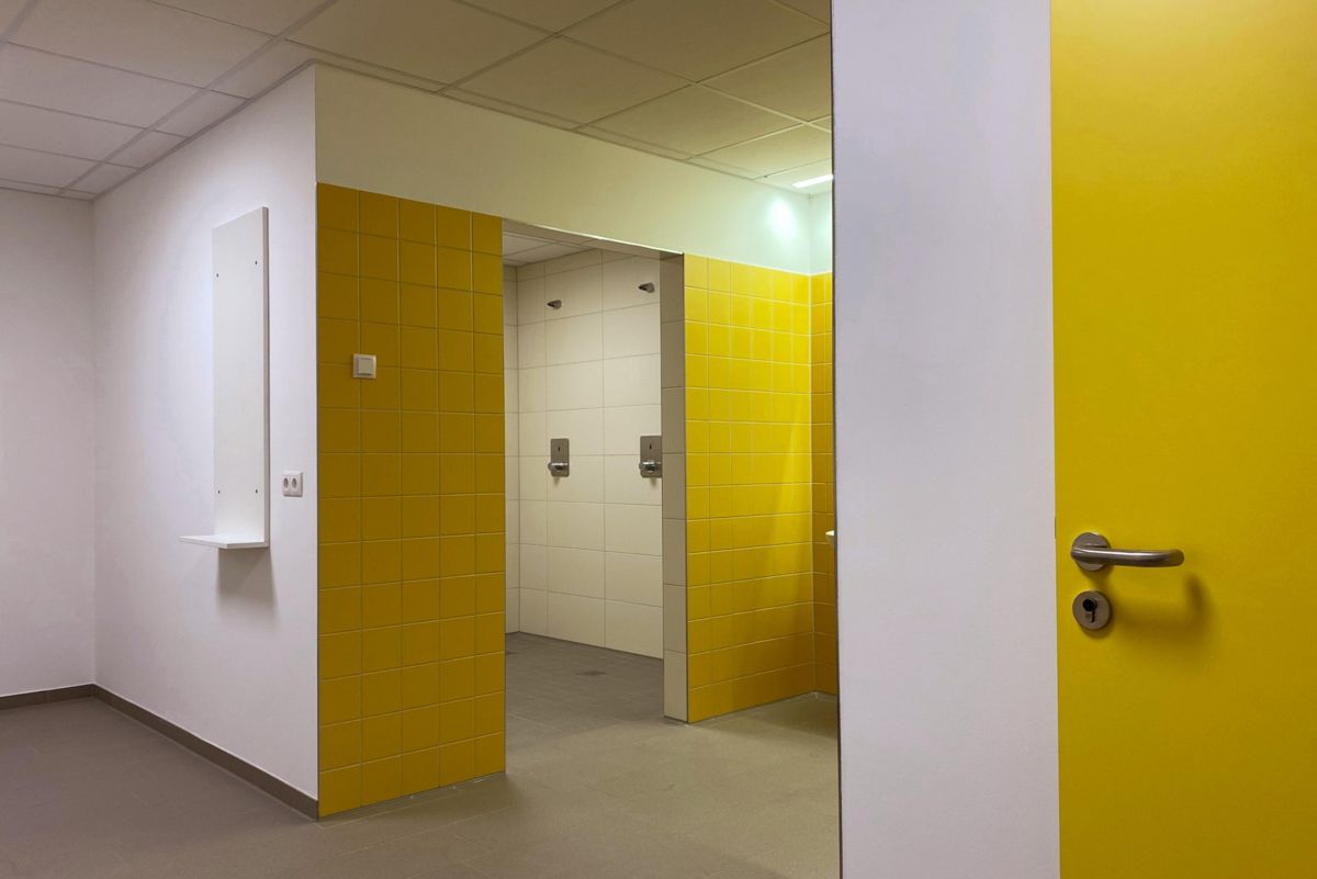 Ein Flur mit einer gelben Tür, die zu einem Badezimmer führt.