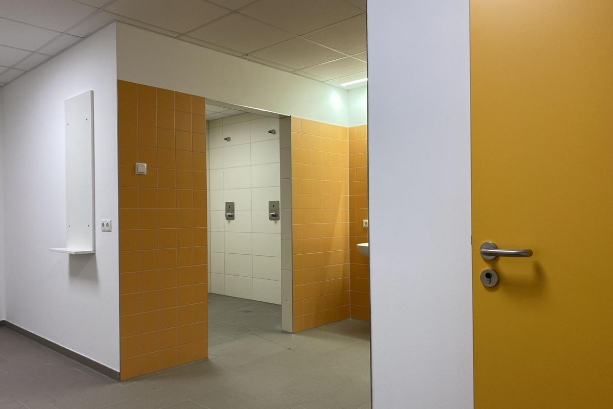 Ein Flur mit einer gelben Tür, die zu einem Badezimmer führt.