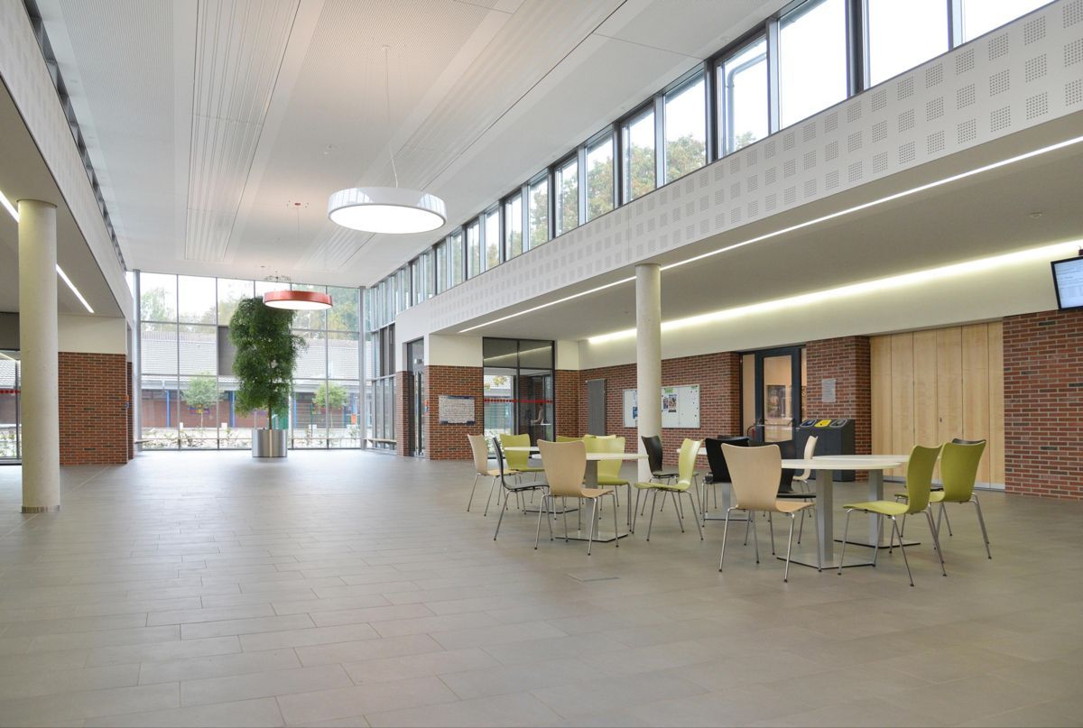 Ein großer Raum mit Tischen und Stühlen.