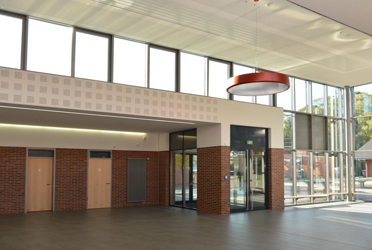 Ein großer leerer Raum mit vielen Fenstern und Türen.