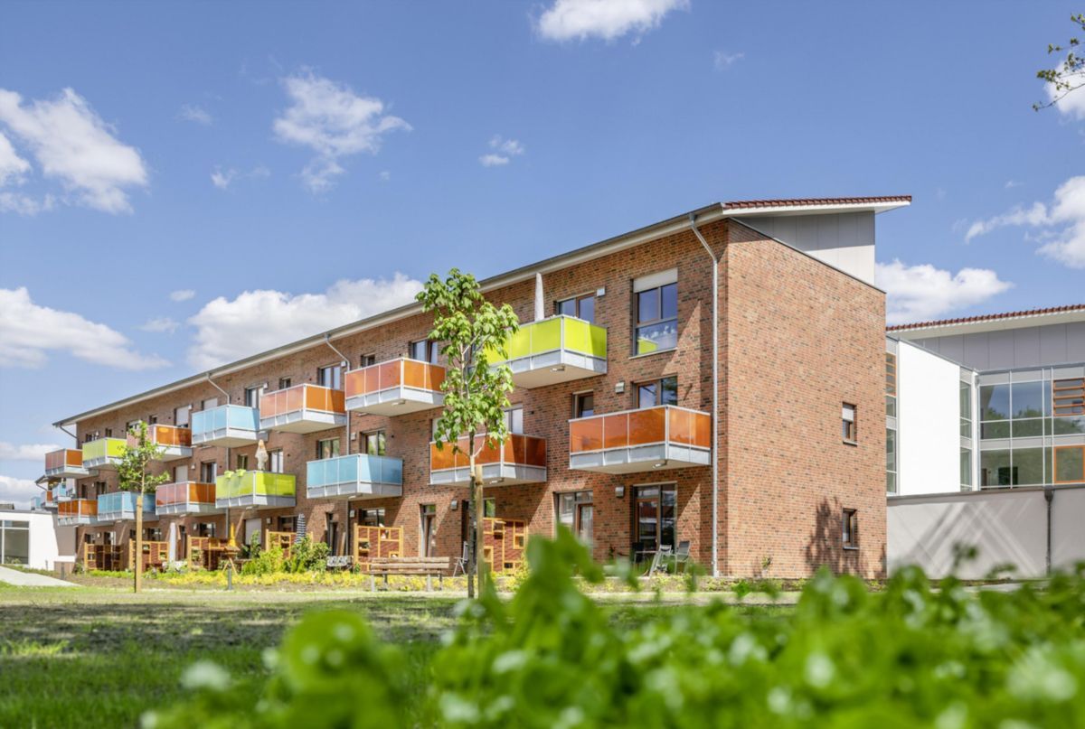 Ein großes Backsteingebäude mit vielen Balkonen an einem sonnigen Tag.