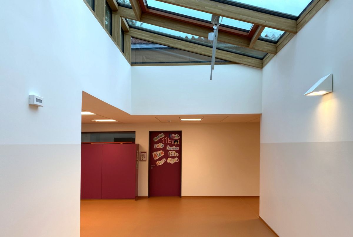 Ein Flur mit einer roten Tür und einem Oberlicht