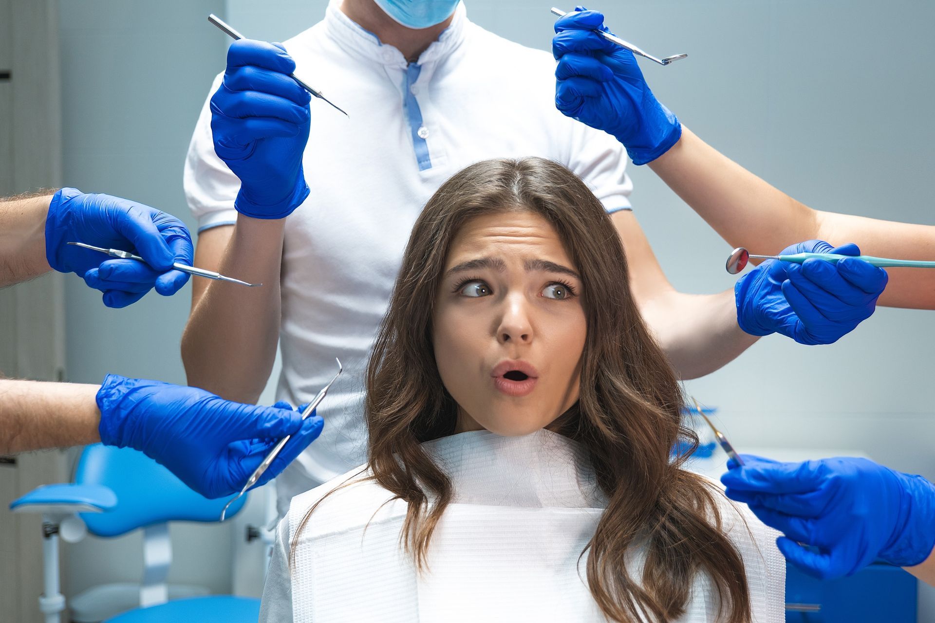 Una mujer está sentada en una silla dental rodeada de instrumentos dentales.