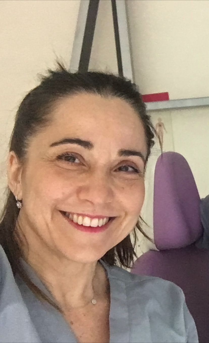 Una mujer con una bata de laboratorio está sonriendo en un laboratorio.