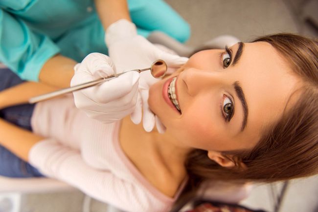 Una mujer está siendo examinada por un dentista.