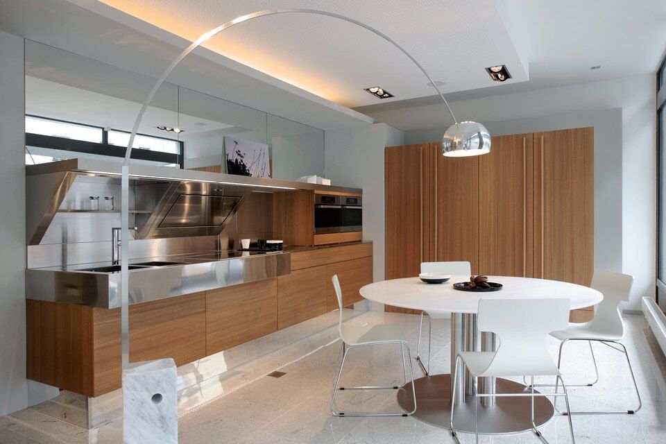 Eine Küche mit Tisch und Stühlen und einer Lampe. Foto von Sandro Luisi Küchenbau