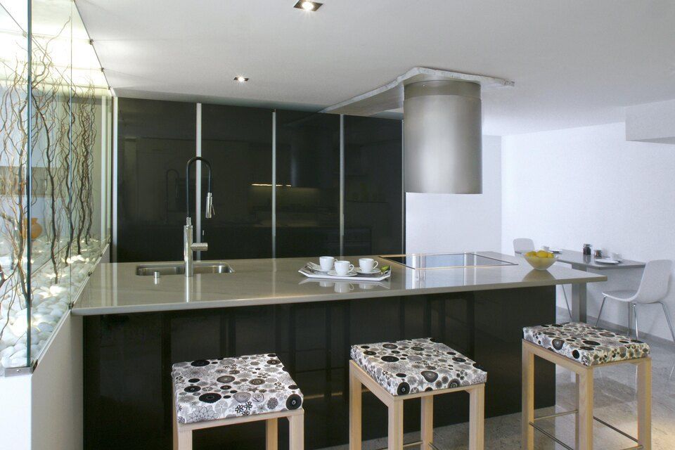 Eine Küche mit grosser Kochinsel und Hockern. Foto von Sandro Luisi Küchenbau