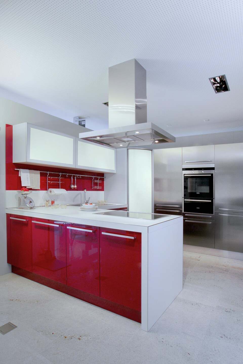 Eine Küche mit roten Schränken und Geräten aus Edelstahl. Foto von Sandro Luisi Küchenbau