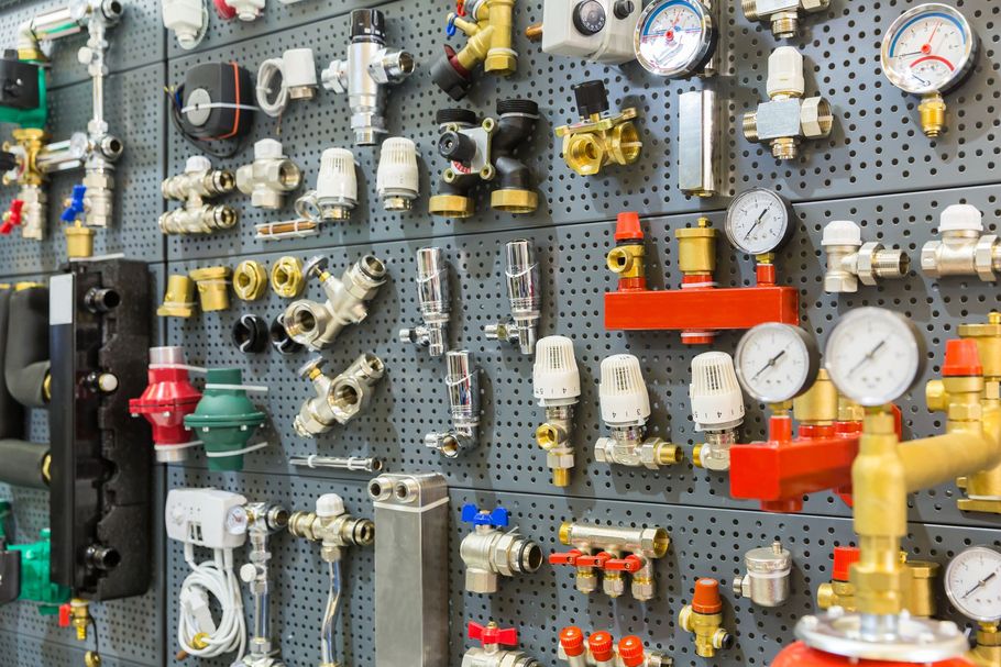 Mur de présentation de plusieurs équipements dans un atelier : vannes, manomètres et tuyaux industriels.