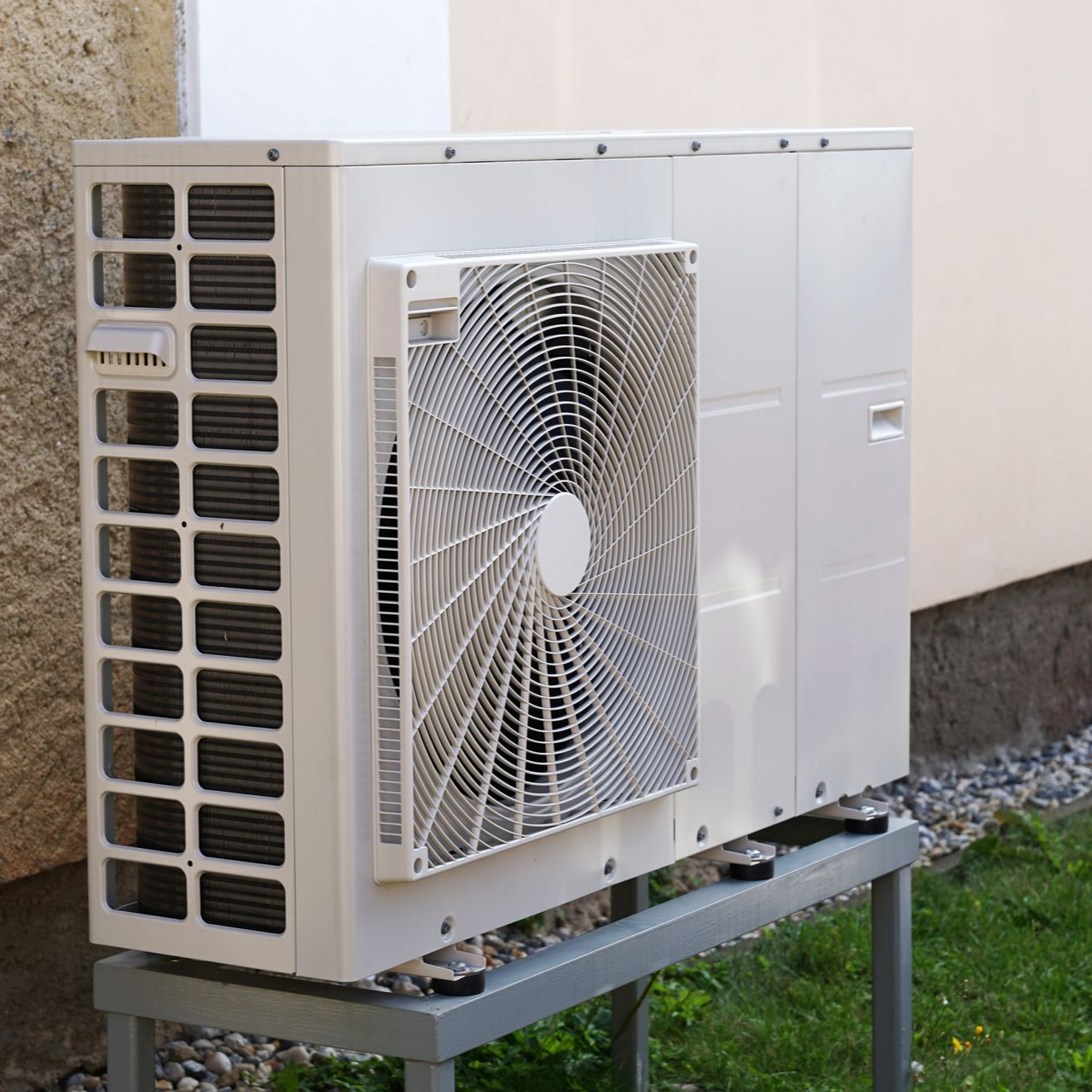 Unité de condensation extérieure d'un climatiseur sur un support métallique à côté d'un mur