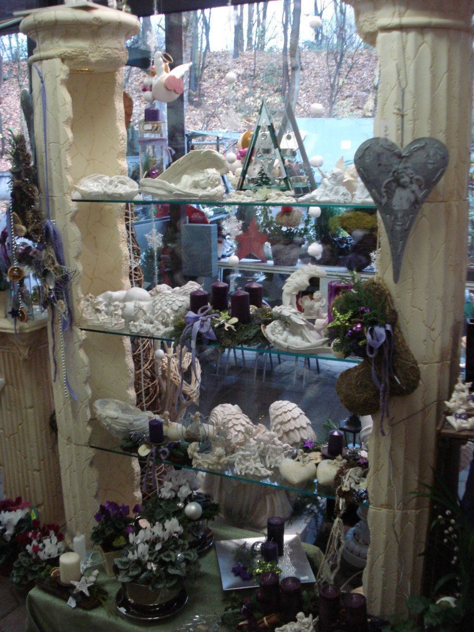 winterliche Dekorationsartikel mit Adventskränzen mit lilafarbenen Kerzen und weißen Engeln