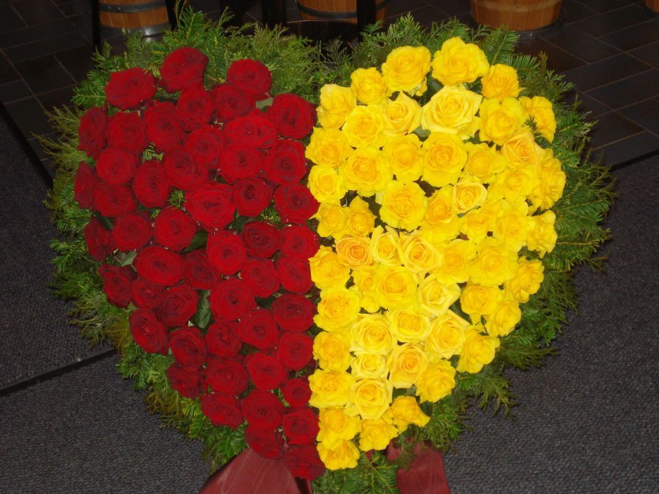 herzförmiges Blumengesteck aus roten und gelben Rosen