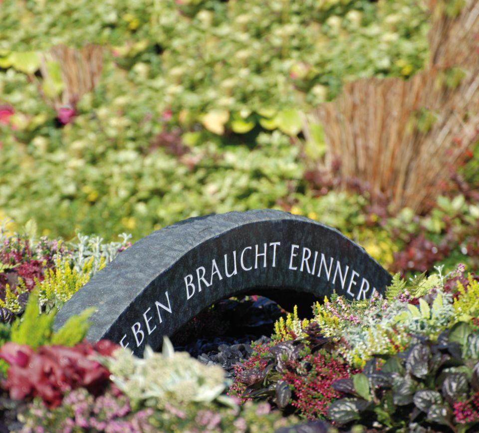 Grabmal auf bepflanzter Fläche mit Erika