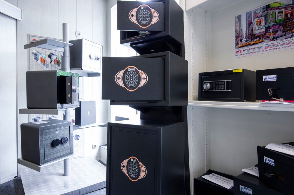 Présentation de différents coffres-forts noirs avec claviers numériques et serrures à combinaison dans un magasin.