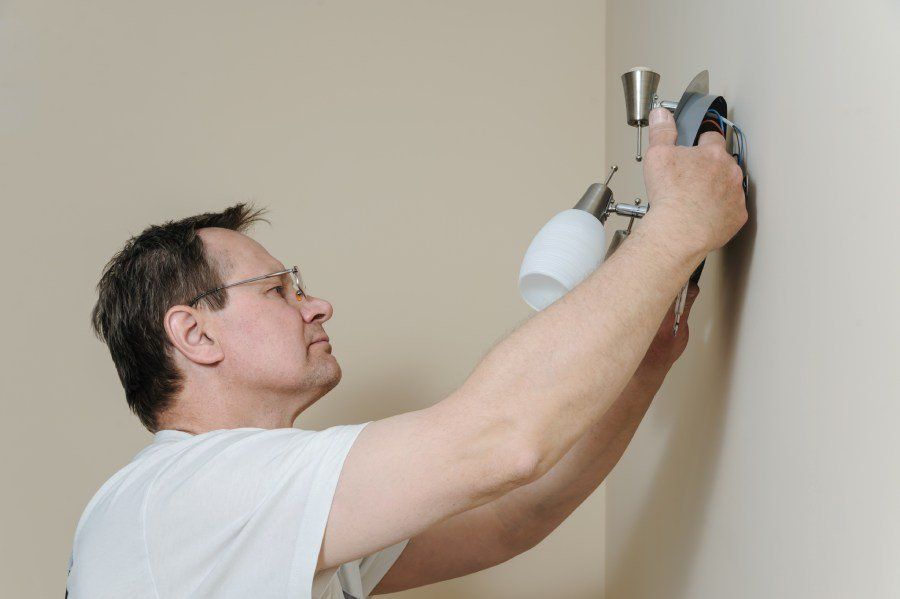Man installiert Wandlampe