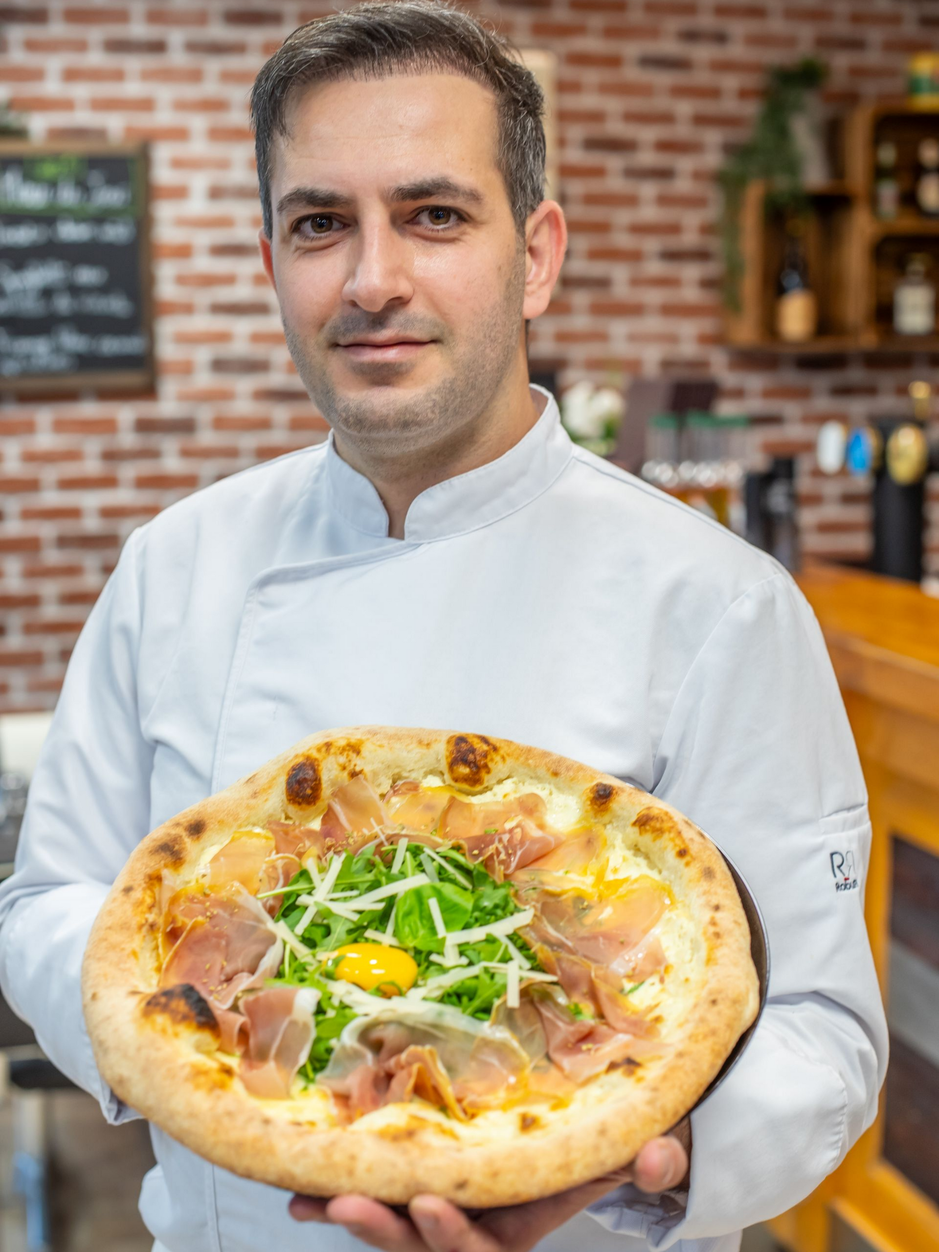 Des mains pétrissent la pâte, la farine tourbillonne autour d'elles.
