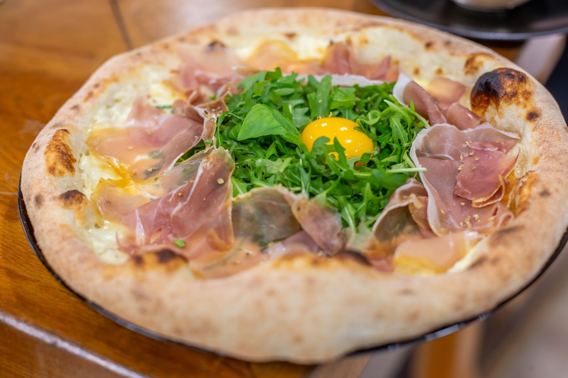 Pizza dans une boîte en carton ouverte sur une table blanche, garnie de poivrons verts, de champignons et de pepperoni.